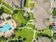 Aerial view of community amenities including a pool, hot tub, green spaces, and apartment building rooftops at 6524 Swissco Dr # 1012, Orlando, FL 32822