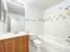 A well-lit bathroom featuring a tub with tiled surround, vanity with wood cabinets, and a large mirror at 6524 Swissco Dr # 1012, Orlando, FL 32822