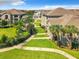 Exterior community lawn and landscaping featuring a walkway to apartment units and verdant landscape at 6524 Swissco Dr # 1012, Orlando, FL 32822