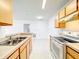 Bright kitchen features white appliances and cabinets with a view to living area at 6524 Swissco Dr # 1012, Orlando, FL 32822