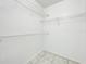 A bright, white walk-in closet with white wire shelving and tile floors offers efficient storage at 6524 Swissco Dr # 1012, Orlando, FL 32822