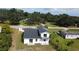 An aerial view showcasing the backyard with a deck, patio, new roof, green space, and mature trees at 9122 Trevarthon Rd, Orlando, FL 32817