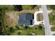 A bird's-eye view displays the home's layout, roof, long driveway, lush greenery, and surrounding neighborhood at 9122 Trevarthon Rd, Orlando, FL 32817