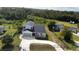 An aerial view showcasing the backyard with a new roof, attached garage, and lush greenery surrounding the property at 9122 Trevarthon Rd, Orlando, FL 32817