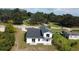 An aerial view showcasing the backyard with a deck, patio, new roof, green space, and mature trees at 9122 Trevarthon Rd, Orlando, FL 32817