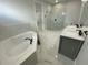 Luxurious bathroom with a soaking tub, glass-enclosed shower, marble tile, and double vanity at 9122 Trevarthon Rd, Orlando, FL 32817