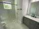 Modern bathroom featuring a glass walk-in shower and vanity with elegant marble countertops at 9122 Trevarthon Rd, Orlando, FL 32817