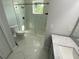 Contemporary bathroom boasts a sleek glass shower, marble countertops and modern fixtures at 9122 Trevarthon Rd, Orlando, FL 32817