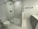 Bathroom featuring a modern glass shower, toilet, and vanity with marble-look tile flooring at 9122 Trevarthon Rd, Orlando, FL 32817