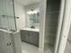 Bathroom view highlighting a glass shower, vanity, and open closet with wire shelving at 9122 Trevarthon Rd, Orlando, FL 32817