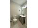 Compact bathroom with a marble vanity, modern sink, and white toilet at 9122 Trevarthon Rd, Orlando, FL 32817