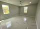 A spacious bedroom with marble floors, ceiling fan, and ample natural light from the windows at 9122 Trevarthon Rd, Orlando, FL 32817