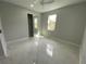 Bright bedroom with marble floors, closet, ceiling fan and a window view to the neighborhood at 9122 Trevarthon Rd, Orlando, FL 32817