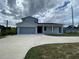 New two-story home featuring modern design, a spacious driveway, and an attached two-car garage at 9122 Trevarthon Rd, Orlando, FL 32817