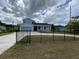 Inviting two-story home with a well-manicured front yard and a black wrought iron fence at 9122 Trevarthon Rd, Orlando, FL 32817