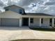 New two-story home with modern design, a spacious driveway, covered porch, and an attached two-car garage at 9122 Trevarthon Rd, Orlando, FL 32817