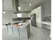 Modern kitchen features white cabinets, stainless appliances, island with pendant lights, and beautiful backsplash at 9122 Trevarthon Rd, Orlando, FL 32817