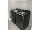Modern laundry room showcasing a black, front-load washer and dryer set, complemented by white tiled flooring at 9122 Trevarthon Rd, Orlando, FL 32817
