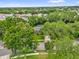 An aerial view showcases a home nestled among mature trees in a verdant neighborhood at 9275 Lake Sharp Ct, Orlando, FL 32817