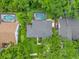 Aerial view of a home with a screened pool, lush landscaping, and a well-maintained gray shingle roof at 9275 Lake Sharp Ct, Orlando, FL 32817