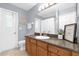Well-lit bathroom featuring a wooden vanity with gray countertops and decorative accents at 9275 Lake Sharp Ct, Orlando, FL 32817