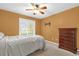 Cozy bedroom with a ceiling fan and natural light from a large window at 9275 Lake Sharp Ct, Orlando, FL 32817
