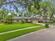 Charming single-story home featuring a lush lawn, mature trees, and a welcoming two-car garage at 9275 Lake Sharp Ct, Orlando, FL 32817