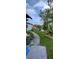 Backyard with sidewalk, lush foliage, plants, and blue sky at 10928 Tangora St, Orlando, FL 32825