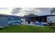 Spacious backyard featuring a covered patio, grassy area, and additional storage shed for outdoor activities at 10928 Tangora St, Orlando, FL 32825