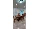 Dining area with a wooden table set for four, natural light, and tiled flooring at 10928 Tangora St, Orlando, FL 32825