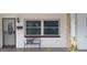 Close-up view of the front entrance with secure gate, butterfly bench, and white painted brick at 10928 Tangora St, Orlando, FL 32825