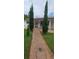Charming home with a brick walkway, secure gated entry, and mature trees in the front yard at 10928 Tangora St, Orlando, FL 32825