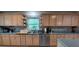 Open kitchen with stainless steel dishwasher, light wood cabinets, and window at 10928 Tangora St, Orlando, FL 32825