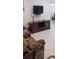 Cozy living room features tile flooring, patterned chair and dark wood media console at 10928 Tangora St, Orlando, FL 32825