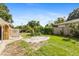 Lush backyard with a well-kept lawn, garden area, fence, and partial view of the home at 1104 W Marjorie St, Lakeland, FL 33815