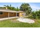 Spacious backyard featuring well-kept lawn, outbuildings, and attached covered parking under sunny skies at 1104 W Marjorie St, Lakeland, FL 33815