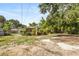 Charming single-story home with landscaped yard, bamboo and mature trees under a sunny sky at 1104 W Marjorie St, Lakeland, FL 33815