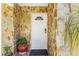Close-up of the front door with stone surround, potted plant, and welcome mat at 1104 W Marjorie St, Lakeland, FL 33815