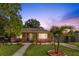 Charming single-story home with a well-manicured lawn, landscaped garden, and inviting front porch seating at 1104 W Marjorie St, Lakeland, FL 33815