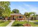 Inviting home exterior with manicured lawn, stone accents, and comfortable seating on the front porch at 1104 W Marjorie St, Lakeland, FL 33815