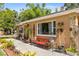 Charming single-story home featuring stone accents, large windows, and outdoor seating at 1104 W Marjorie St, Lakeland, FL 33815