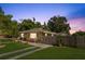 Single-story home featuring a well-kept lawn, a gated carport, and a paved driveway at 1104 W Marjorie St, Lakeland, FL 33815
