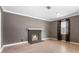 Empty living room featuring a fireplace, gray walls, light wood flooring, and natural light from the window at 1104 W Marjorie St, Lakeland, FL 33815