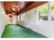 Enclosed sunroom with wood ceiling, multiple windows, bright white walls, and indoor/outdoor flooring at 1104 W Marjorie St, Lakeland, FL 33815