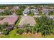 Aerial view of a home featuring a screened-in lanai, surrounded by lush landscaping and mature trees in a quiet neighborhood at 1254 Spartanburg Way, The Villages, FL 32162