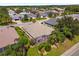 Expansive aerial view of a home with a screened-in lanai and beautifully landscaped yard in a residential neighborhood at 1254 Spartanburg Way, The Villages, FL 32162