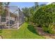 Backyard with screened-in lanai and lush green grass at 1254 Spartanburg Way, The Villages, FL 32162