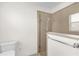 Clean bathroom with glass door shower and white toilet at 1254 Spartanburg Way, The Villages, FL 32162