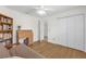 Inviting bedroom with hardwood floors, built-in shelving, closet, and a comfortable futon at 1254 Spartanburg Way, The Villages, FL 32162