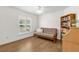 Comfortable bedroom with a futon, hardwood floors, a window with shutters, and a built-in bookshelf at 1254 Spartanburg Way, The Villages, FL 32162